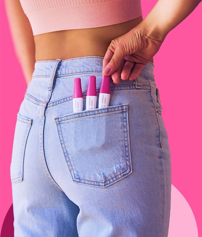 Woman with First Response pregnancy test sticks in back pocket.