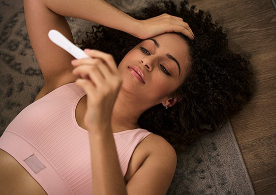 Woman reading First Response pregnancy test.